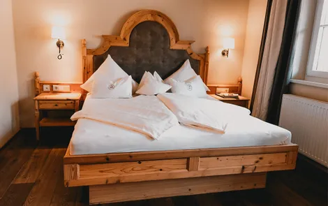 Heimat Cozy hotel room with large wooden bed, white bedding, and bedside tables